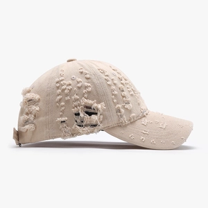 Distressed khaki cotton baseball cap with vintage frayed holes and a soft curved brim