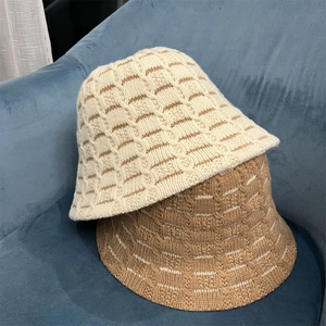 Winter knitted wool bucket hat in beige and coffee stripes on blue velvet seat