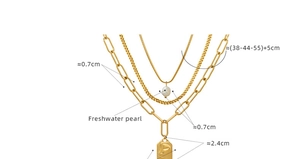 Detailed view of triple-layered gold necklace with freshwater pearl and face relief pendant