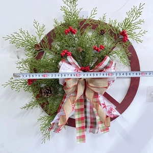 Detail shot of a 40cm Christmas wreath with wood wheel, pine cones and red berries