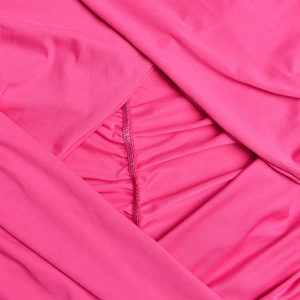 Macro shot of bright pink stretchy fabric detailing the ruching and fine stitching quality