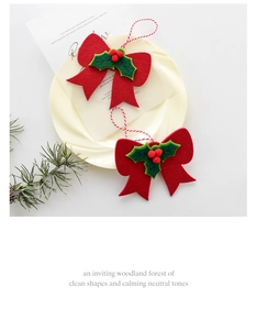 Detail of Christmas felt bow ornaments with red berries on a cream plate decor