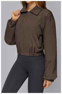 Detail of a dark brown windproof sports jacket with zipper, lapel, and elasticated hem