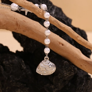 Detail of silver starfish and shell charms with crystals on a delicate pearl necklace