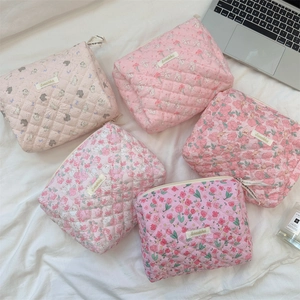 Detailed set of quilted cotton cosmetic bags with floral patterns and ribbon zippers