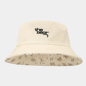 Close-up of beige sun hat with bear embroidery and 'Hello Bear' printed inner lining