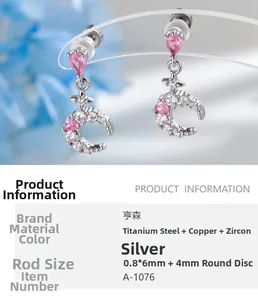 Detailed view of silver moon pendant earring featuring pink drop-shaped zircon stones