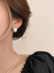 Close-up of French vintage irregular pearl ear cuff with silver lava texture on model