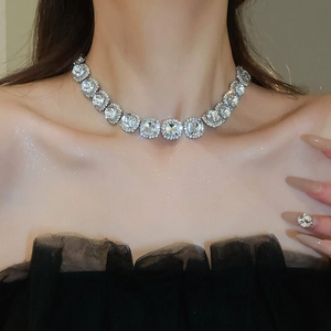 Close-up of sparkling crystal floral necklace and ring set on model in black top