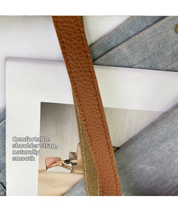 Detail of brown litchi pattern leather strap with contrast stitching and green lining