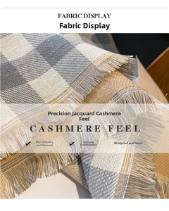 Macro detail of plaid cashmere-feel fabric with tassels showing the soft woven texture