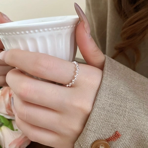 Silver beaded wavy ring on model holding coffee cup in a minimalist lifestyle setting