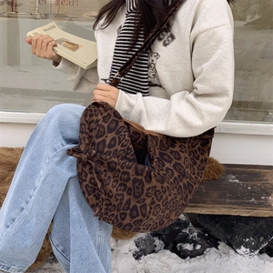 Detail of slouchy leopard print shoulder bag with zipper closure in a winter setting