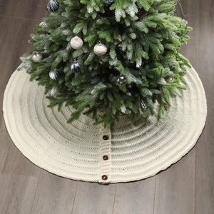 Detail of cream white cable knit Christmas tree skirt with dark wood button closures