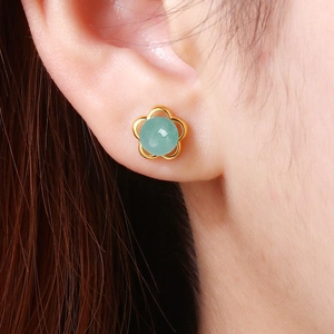 Elegant gold flower earrings with green aventurine stone shown on ear