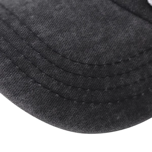 Detail of grey washed cotton baseball cap brim showing premium triple stitching texture