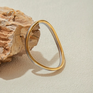 Dettaglio di un bracciale a onde minimalista in acciaio inossidabile oro e argento