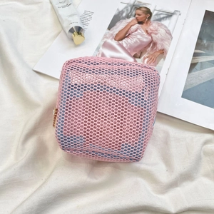 Macro view of the pink mesh cube makeup bag featuring a smooth zipper and side fabric tag