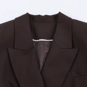 Détails du revers en pointe et de la finition de l'encolure sur le blazer foncé