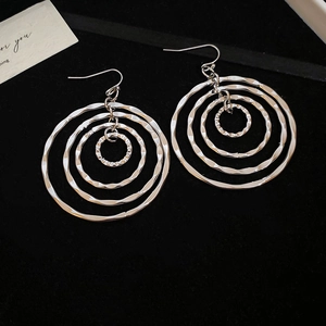 Macro view of textured silver layered concentric circle earrings with metallic finish