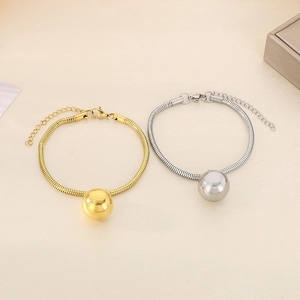Detail of 18K gold and silver snake chains with hollow ball pendants and lobster clasps