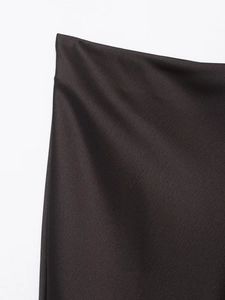Détail du tissu en satin foncé de haute qualité montrant une texture lisse et brillante
