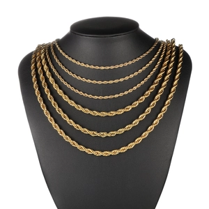 Detail of layered gold-plated stainless steel rope chain necklace on a black mannequin
