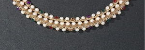 Detail of multi-layer gold chain with white pearls and colorful rhinestones