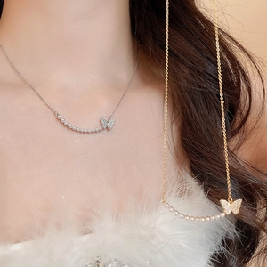 Detail of 18k gold and silver butterfly necklaces with pearls and sparkling crystals