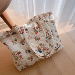 Detail of quilted cotton tote bag with vintage rabbit print and diamond stitching pattern