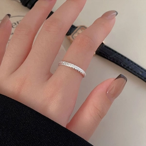Detailed view of 925 silver Greek style braided ring worn on finger with elegant watch