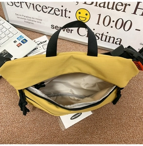 Detailed interior of yellow nylon crossbody bag with open zipper and internal layering