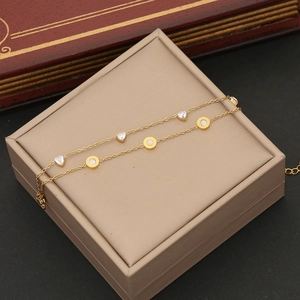 Close-up of golden double-layer heart zircon bracelet with Roman numeral charm