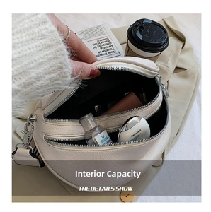Detail showing inner capacity of cream leather saddle bag with double zipper closure
