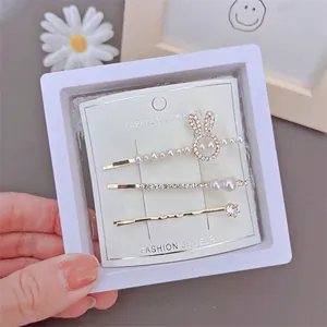 Three-piece gold hair clip set with bunny pearl and crystal details in elegant style