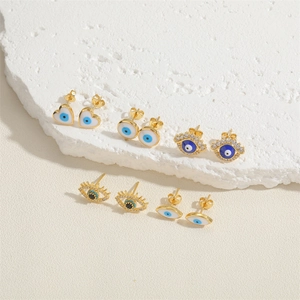 Detailed view of evil eye stud earrings with blue enamel and sparkling zircon accents