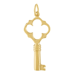 Macro detail of a golden clover key pendant showing the polished metal finish and fine engraving