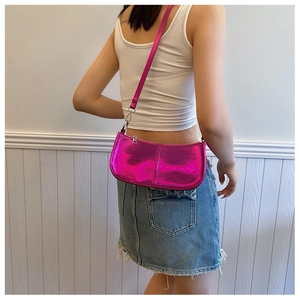 Détail du sac à bandoulière rose rouge métallisé avec coutures verticales et sangle réglable