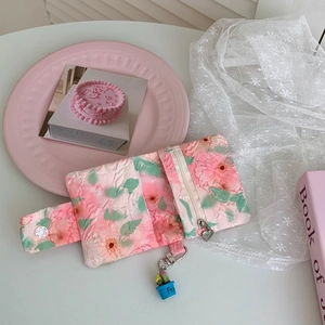 Detailed view of floral puffy card holder with textured fabric and flower charm