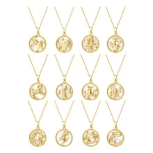 Macro view of twelve gold constellation pendant necklaces with embossed zodiac symbols