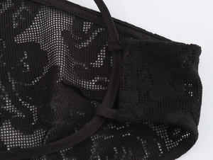 Detailed close-up of intricate black floral lace pattern and mesh fabric texture