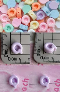 Macro shot of colorful mini 26-letter resin beads with side holes for DIY jewelry