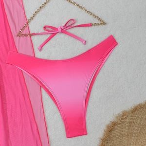 Detailed flat lay of gradient pink bikini with gold chains and mesh sarong cover up
