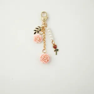 Schlüsselanhänger mit rosa Rosenharz, goldenem Herzverschluss und weißen Perlen