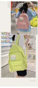Detail of pink and green canvas backpacks with plush bear accessories and side pockets