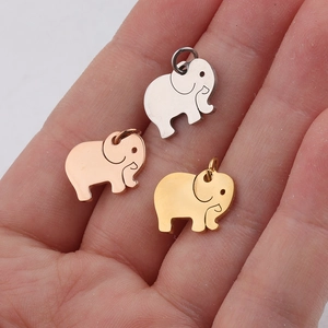 Polished elephant charms in silver, gold and rose gold displayed on a palm for size reference
