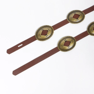 Detail of vintage brown leather belt featuring oval gold buckles with rhombus hollow design