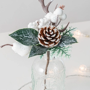 Christmas tree pine cone pick with snow-covered leaves and berries in glass vase