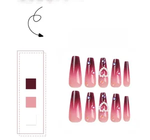 Macro detail of long coffin nails with burgundy gradient, pearls, and heart rhinestones