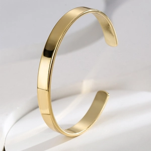 Detailed view of polished gold brass open C-shape cuff bracelet with minimalist smooth finish